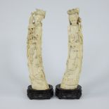 A pair of Japanese ivory sculptures depicting two female goddesses with long robes in a graceful bow