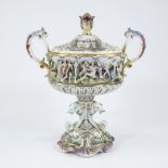 A Baroque Italian Capodimonte lidded porcelain vase with various characters in relief and the base d