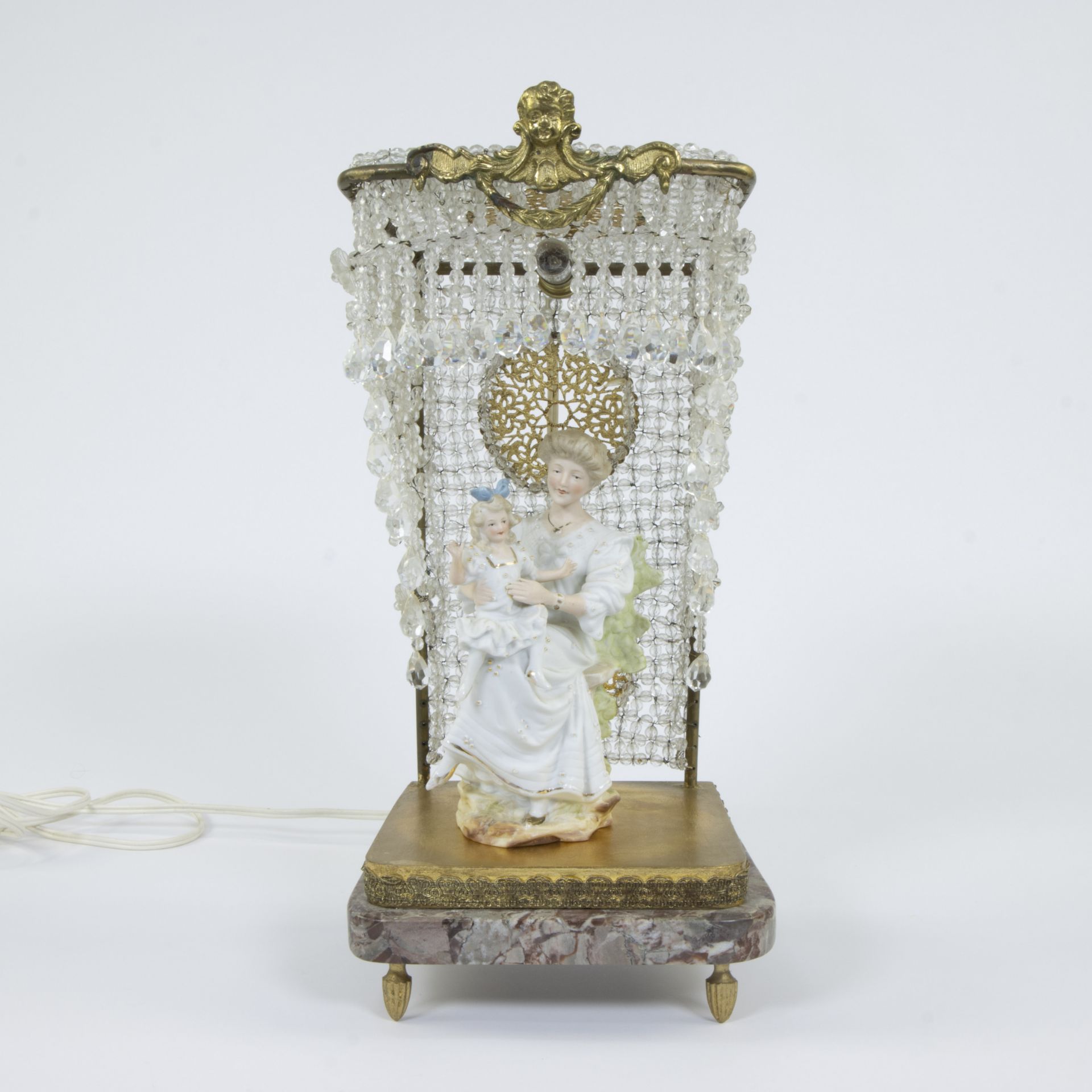 A group of polychromed and gilded porcelain on a brass and marble base with a sky with glass beads a