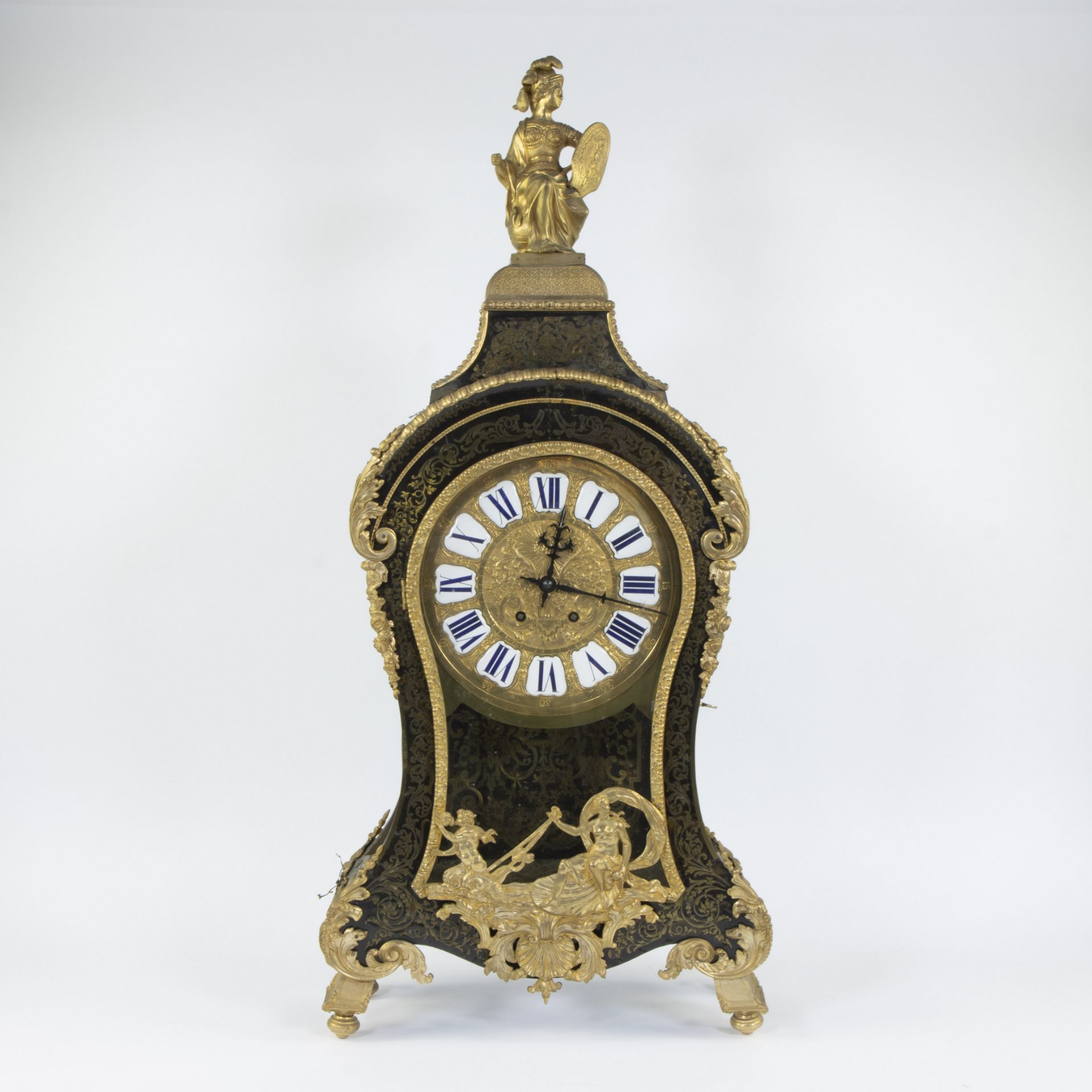A Louis XV-style cartel clock of black-painted wood decorated with a classical figure and rich gilt
