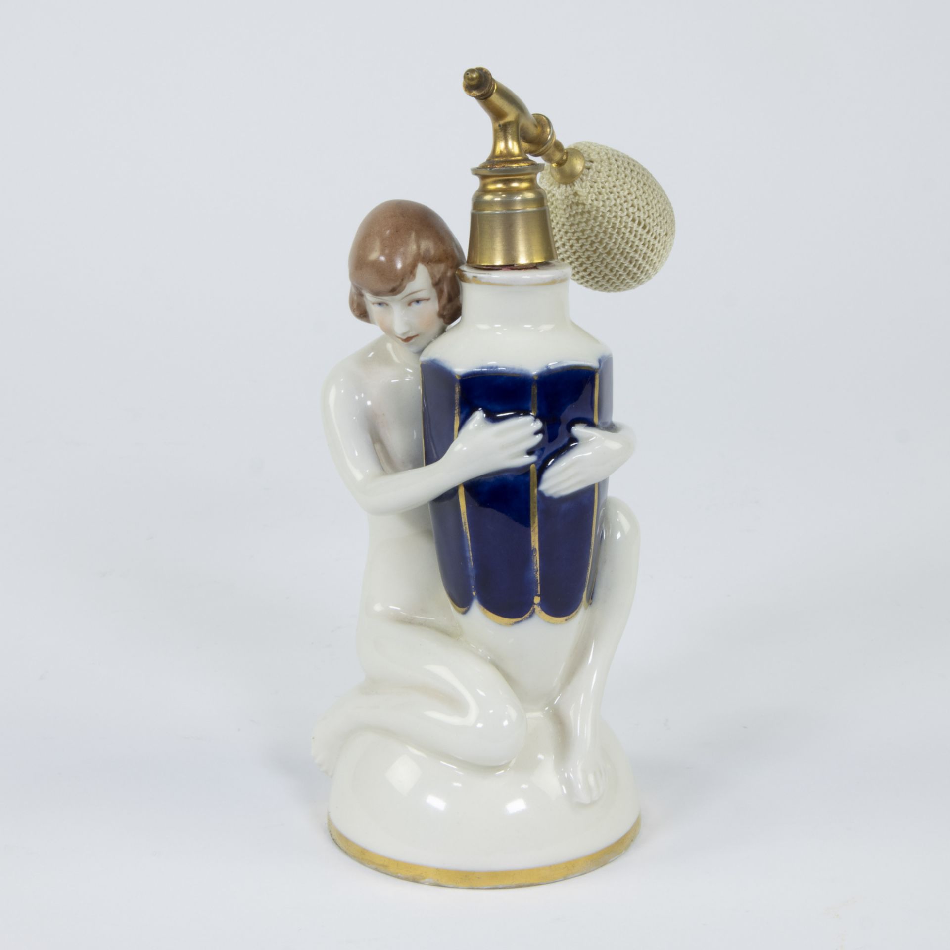 A Royal Dux art deco fine porcelain perfume bottle depicting a nude woman holding a faceted vase dec