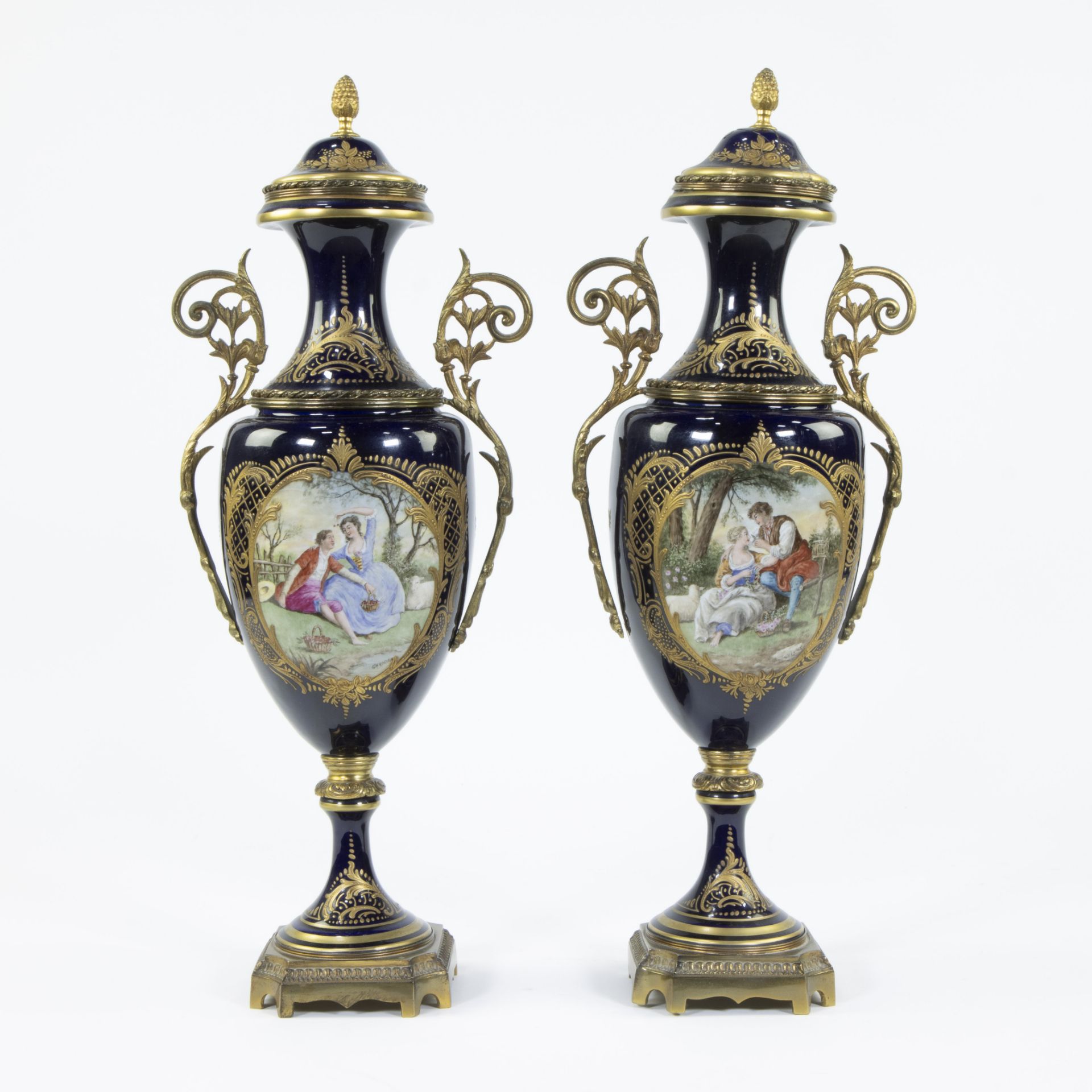 A pair of Sèvres ornamental vases of cobalt blue porcelain and gilt brass and decorated with multi-c