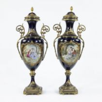 A pair of Sèvres ornamental vases of cobalt blue porcelain and gilt brass and decorated with multi-c