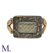 An Antique Mourning Ring in yellow gold, set with a rectangular glass locket panel containing
