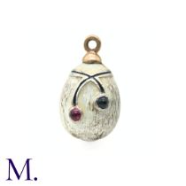 An Enamelled Egg Pendant with white enamel and set with a red and blue spinel. No markings