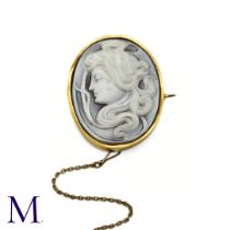 A Cameo Brooch with Gold Frame depicting a woman in profile. Set within a gold border (unmarked