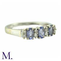 A Tanzanite And Diamond Ring, in 9k white gold, the three oval cut tanzanites punctuated by pairs of