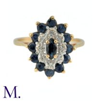 A Sapphire and Diamond Ring in 9k yellow gold, the central marquise cut sapphire surrounded by a