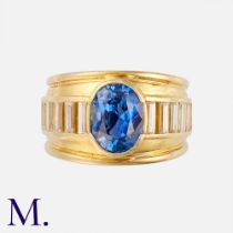 A Sapphire & Diamond Ring in 18K yellow gold, set with an oval-cut sapphire accompanied by a