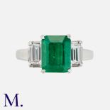 An Emerald & Diamond Three Stone Ring in platinum, set with a principal step cut emerald of