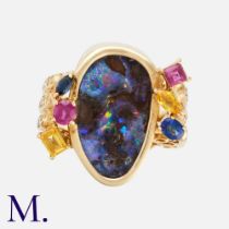 An Opal, Ruby & Sapphire Ring in 18k yellow gold, set with a boulder opal, accented with rubies