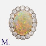 An Opal And Diamond Cluster Ring in platinum and yellow gold, set with a principal cabochon opal