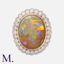 An Opal And Diamond Cluster Ring in 18k gold and platinum, comprising a principal rub-over set