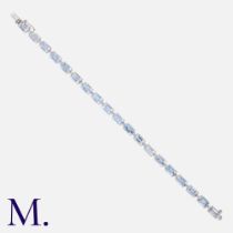 An Aquamarine & Diamond Bracelet in 18k white gold, comprising a row of step cut aquamarines