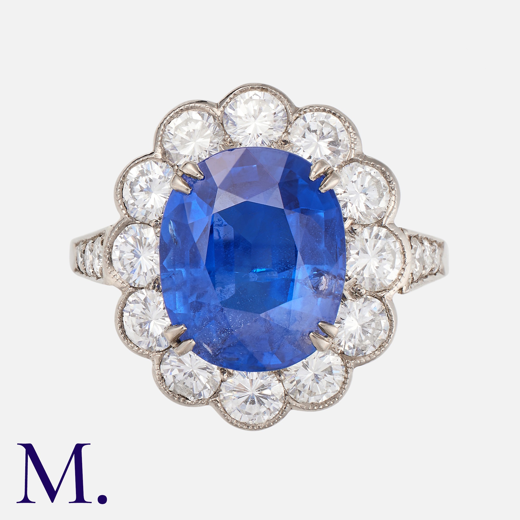 A Burma No Heat Sapphire And Diamond Cluster Ring in platinum, set with a principal blue sapphire of