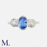 A Sapphire & Diamond 3-Stone Ring in platinum, set with a principal oval cut blue sapphire of