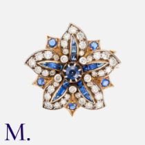 A Sapphire & Diamond Flower Brooch in yellow gold, the floral form set with calibre cut sapphires,