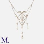 A Diamond & Pearl Pendant Necklace in 18k yellow and white gold, the openwork foliate and bow form