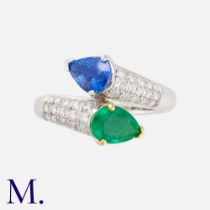 A Sapphire & Emerald Toi Et Moi Ring in 18k white gold, of crossover design, set with a pear