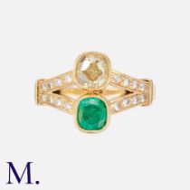 An Emerald & Diamond Ring in 18k yellow gold, set with a cushion cut diamond of approximately 1.