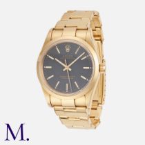 Rolex. An Oyster Perpetual Wristwatch in 18ct yellow gold, 14208, the black dial with applied gilt