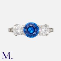 A Sapphire & Diamond Ring in platinum, the central round cut blue sapphire of approximately 0.