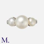 A Natural Pearl Three Stone Ring in platinum set with three pearls to an engraved band. With a