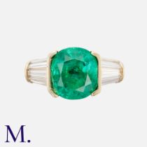 An Emerald & Diamond Ring in 18k yellow gold, set with a principal cushion cut emerald of