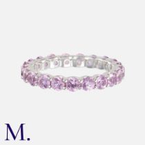 A Pink Sapphire Eternity Ring in 18K white gold, set with 21 round cut pink sapphires. Size: M