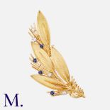CHAUMET. A Sapphire And Diamond Clip in 18K yellow gold. The foliate form set with round cut