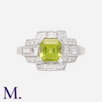 An Art Deco Style Peridot & Diamond Ring in 18k white gold, set with a principal step cut peridot of