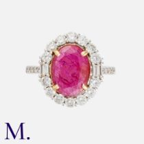 A Ruby & Diamond Cluster Ring in 18k white gold, set with a principal oval cut ruby of approximately