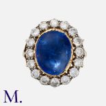 A Sapphire And Diamond Cluster Ring in yellow gold and silver, set with a principal cabochon blue