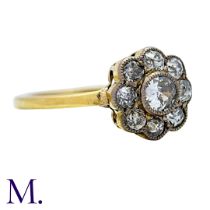 A Diamond Cluster Ring in yellow gold, set with a principal round cut diamond of approximately 0.