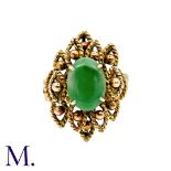 A Jade Ring in 14k yellow gold, set with an oval shaped piece of jade with stylised gold work