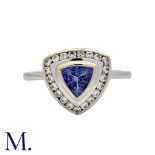 A Tanzanite And Diamond Cluster Ring in 18k white gold, set with a trillion cut tanzanite within a