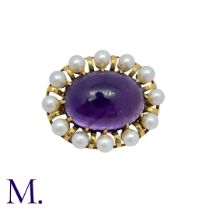 An Amethyst And Pearl Brooch in 14k yellow gold, set with a large cabochon amethyst within a