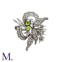 A Diamond And Peridot Brooch in Platinum set with round cut diamonds, baguette cut diamonds and