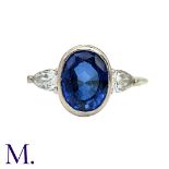 A Blue Stone and Diamond Ring in 14K white gold. The central oval-cut blue stone approximately