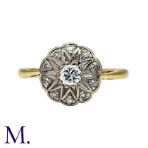 A Diamond Cluster Ring in yellow gold, set with a principal round cut diamond of approximately 0.