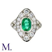 An Emerald and Diamond Ring in platinum, set with a principal oval cut emerald of approximately 1.