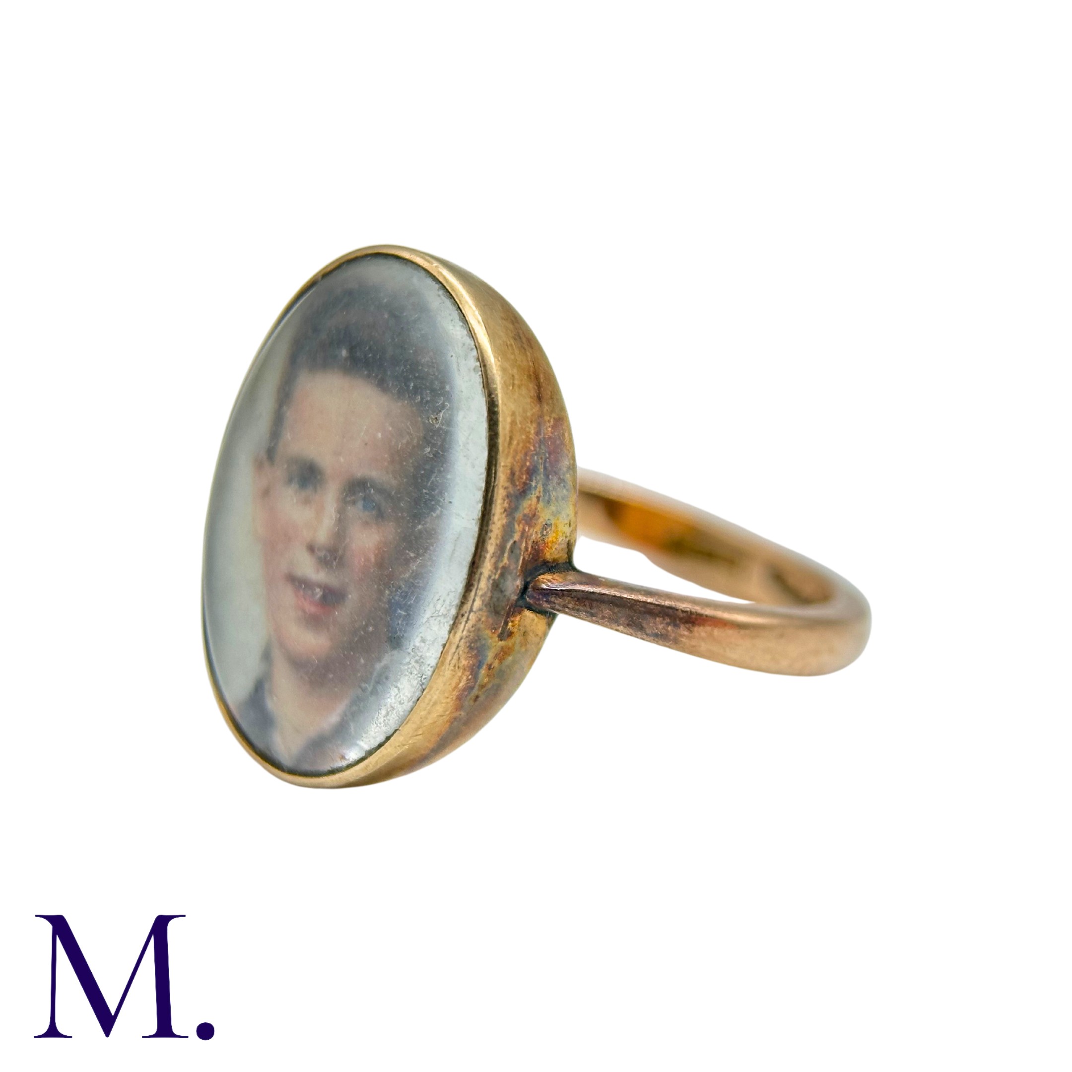 A Portrait Ring in 9k yellow gold, set with a portrait of a young man behind a glass face. Marked