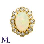 An Opal And Diamond Cluster Ring in 18k yellow gold, set with a principal cabochon opal of