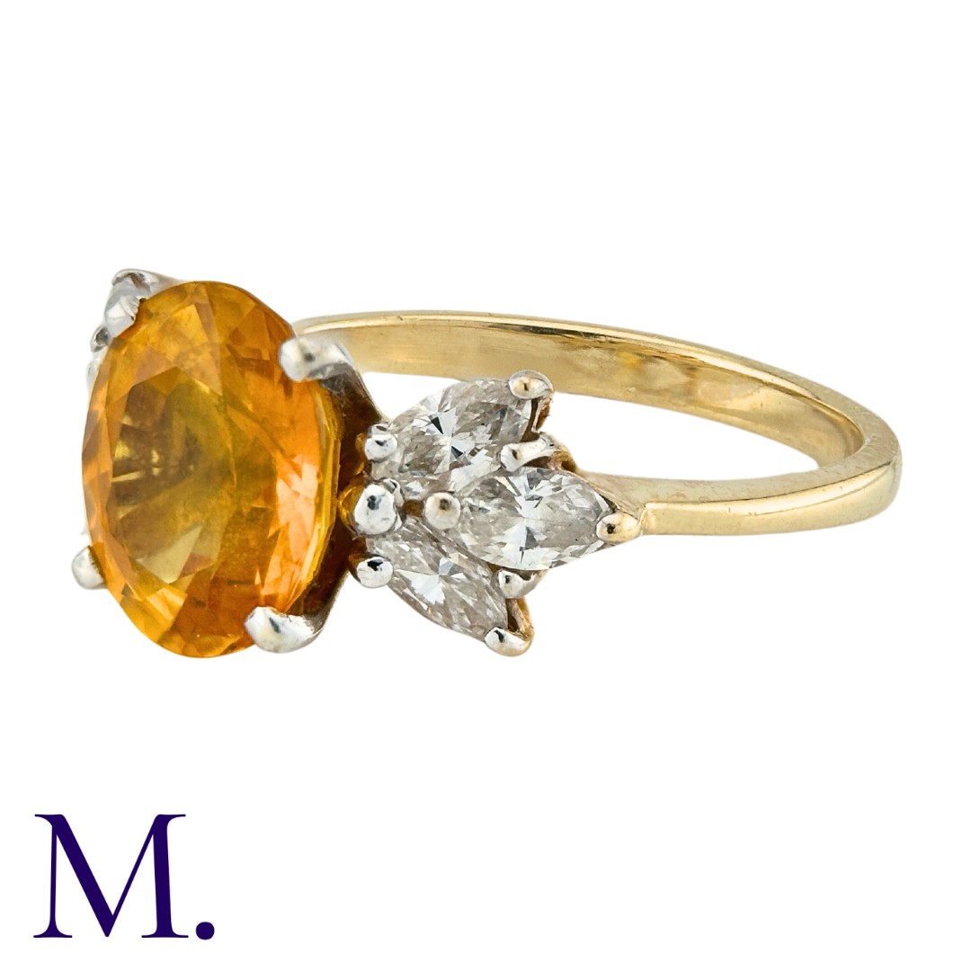 A Sapphire and Diamond Ring in 14K yellow gold, set with an oval cut yellow-orange sapphire of - Image 2 of 3