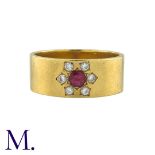 A Ruby and Diamond Gypsy Ring in 18K yellow gold, the wide band set with a round cut ruby surrounded