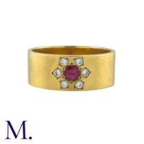 A Ruby and Diamond Gypsy Ring in 18K yellow gold, the wide band set with a round cut ruby surrounded