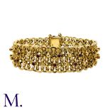 A Garnet-Set Bracelet in 9K yellow gold, set with 26 round cut garnets to a wide, fancy link chain