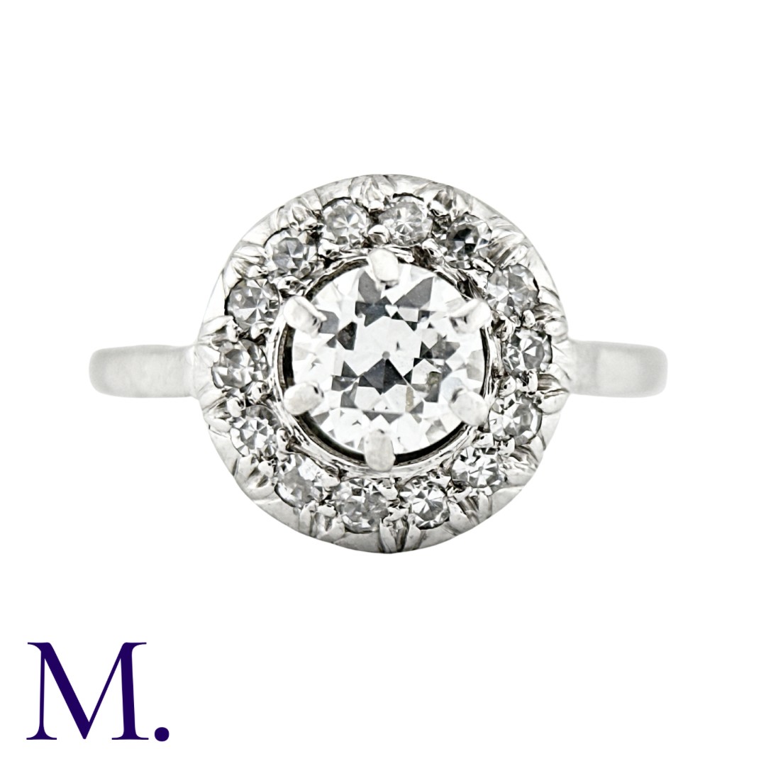 A Diamond Cluster Ring in 18K white gold set with a round cut diamond to the centre with fourteen