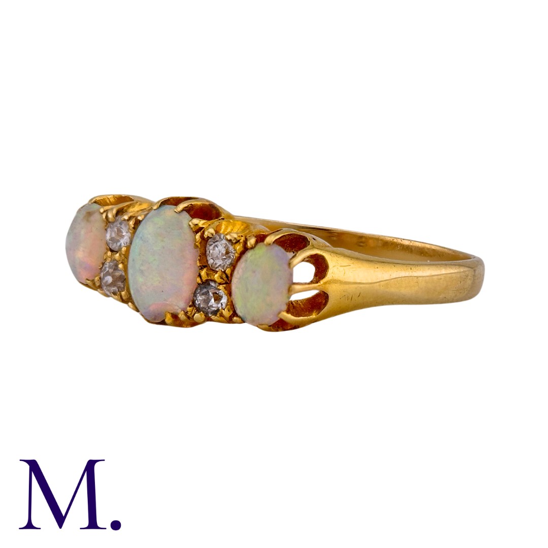 An Opal and Diamond Ring in 18K yellow gold, set with three oval cabochon opals with four round - Image 2 of 3