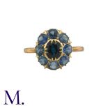 A Sapphire Cluster Ring in yellow gold, comprising a cluster of round cut sapphires surrounding a